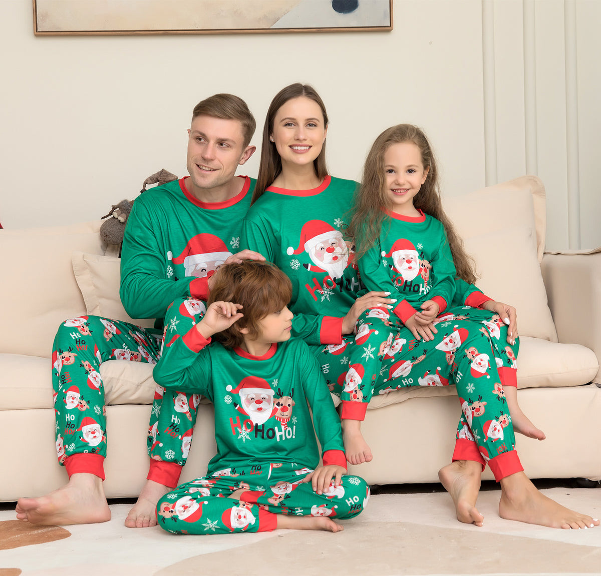 Family on the couch in matching green Santa pajamas